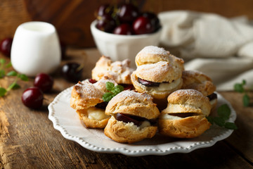 Choux pastry buns with custard and cherry