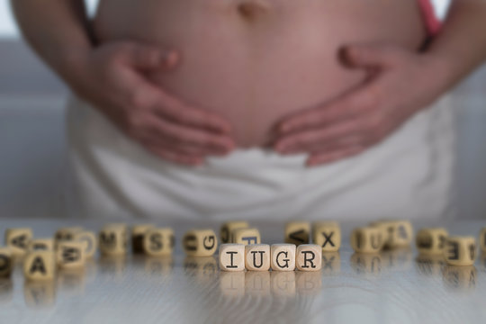 Abbreviation IUGR for intrauterine growth restriction composed of wooden letters.