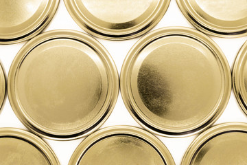 Golden jar lids on white background