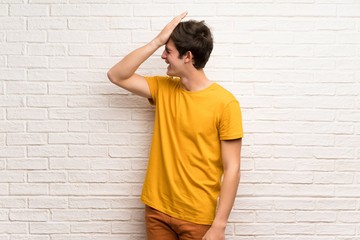 Teenager man over white brick wall has realized something and intending the solution