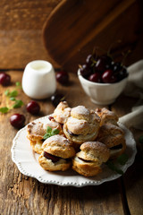 Choux pastry buns with custard and cherry