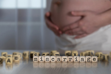 Word MISCARRIAGE composed of wooden letters.