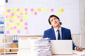 Young handsome employee in front of whiteboard with to-do list  