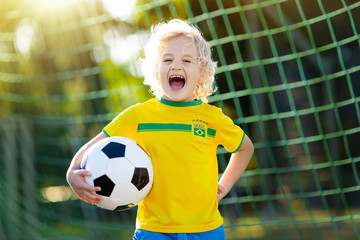 Brazil football fan kids. Children play soccer.