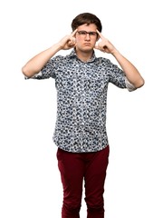 Fototapeta premium Teenager man with flower shirt and glasses having doubts and thinking over isolated white background
