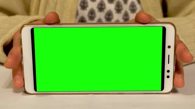 Woman holding a green screen smartphone