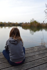 Petite fille de dos au bord de l'eau