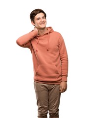 Teenager man with sweatshirt thinking an idea while scratching head over isolated white background