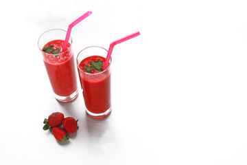 two strawberry smoothies on white background