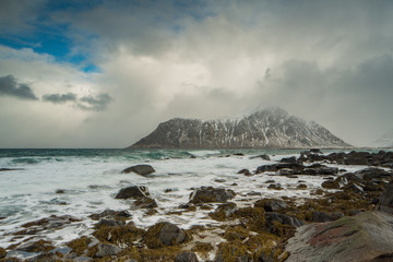 Fototapeta na wymiar Rocks falling into the sea near Skagsanden beach. Lofoten islands, Norway