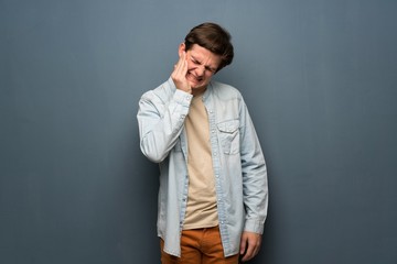 Fototapeta premium Teenager man with jean jacket over grey wall with toothache