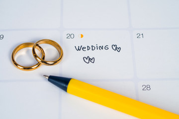 Word Wedding to Reminder Wedding day with Wedding ring on calendar planning and office tool.