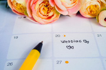 Word Wedding to Reminder Wedding day in calendar planning and pen with heart.