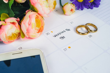 Word Wedding to Reminder Wedding day with Wedding ring on calendar planning and office tool.