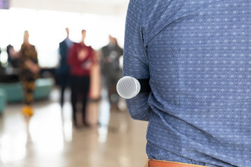 Journalist at press conference, holding microphone