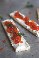 Crackers with cream cheese and red caviar