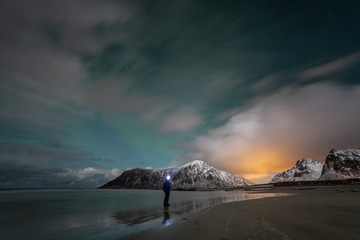 Photographers with tripods during aurora borealis hunting at Skagsanden beach. Lofoten Islands, Norway, Scandinavia