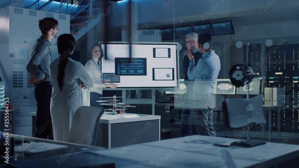 Poster Engineers Meeting in Research Laboratory: Female Engineer Leads Presentation Using Vertical Digital Whiteboard, Shows Machine Blueprint, Data Analytics and Neural Network while Colleagues Listening
