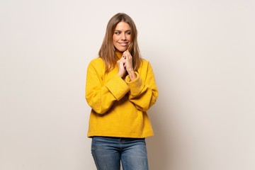 Woman with yellow sweater over isolated wall scheming something
