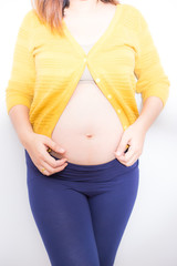 Pensive pregnant women hold hand on belly on white background