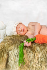 newborn baby in bunny costume sleeping on fur bed