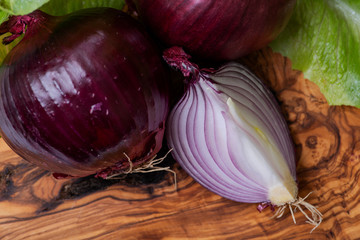 Organic Red Onions arranged on natural olive wood. Allium Cepa.