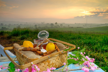 Alternative Medicine with Garlic, Ginger, Honey and Cinnamon on wooden table. Beautiful sunrise as background.