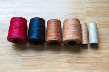 Colorful wax thread on brown wood background
