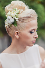 Obraz na płótnie Canvas Elegant wedding hairstyle for the bride blond blonde hair with accessories hairpins from fresh flowers