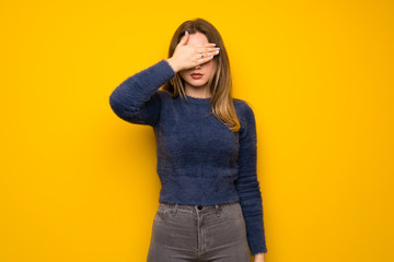 Teenager girl over yellow wall covering eyes by hands. Do not want to see something