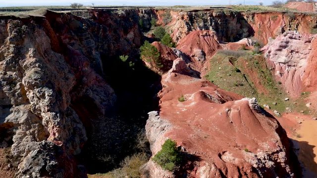 Minervino Murgia, Spinazzola, Apulia, Italy -	March 5 2019:  hiking in abandoned bauxite quarry with pond in the red land of Alta Murgia National Park, Apulia, Italy