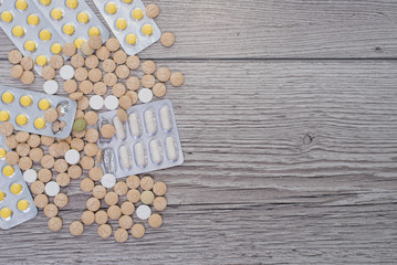 Medical colorful pills, capsules or supplements for the treatment and health care on wooden background.