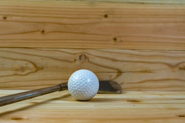 Golf ball and golf club  on wood floor