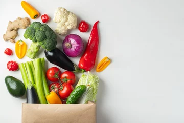 Rolgordijnen Paper bag with vegetables on white background. © Vasiliy