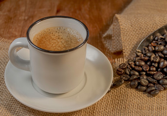 taza de café con tela de yute sobre madera