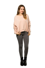 A full-length shot of a Teenager girl with pink sweater laughing looking to the front over isolated white background