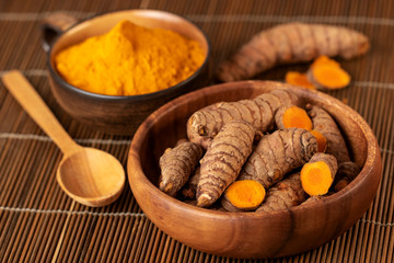 Turmeric roots and powder in close up. Selective focus on turmeric roots