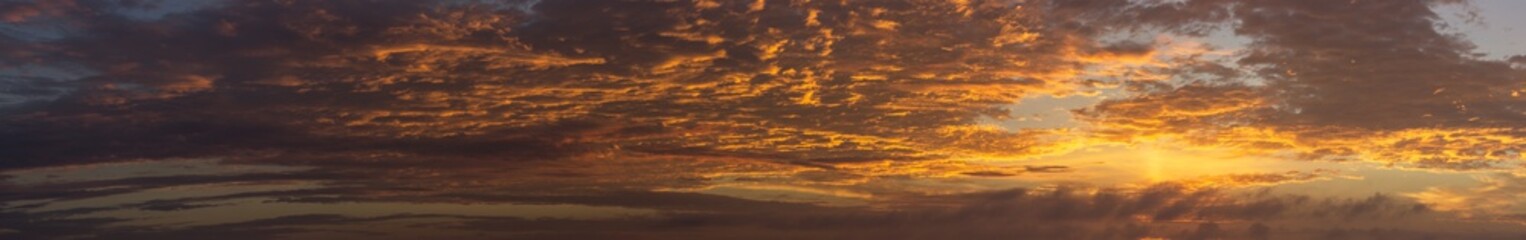 Naklejka na ściany i meble panoramic view of dramatic orange clouds at sunrise