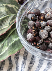 Frozen currant berries in a glass bowl.