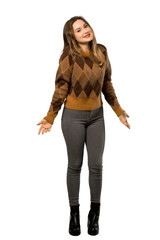 Fototapeta premium A full-length shot of a Teenager girl with brown sweater smiling over isolated white background