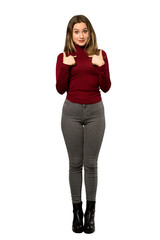 Fototapeta premium A full-length shot of a Teenager girl with turtleneck with surprise facial expression over isolated white background