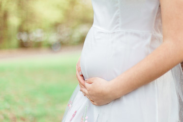 Future mother hugs her pregnant tummy