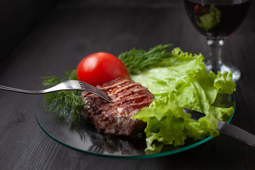 Delicious veal steak served with vegetables and greens