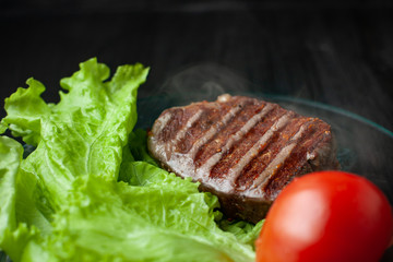 Hot roasted beef on a plate with vegetables. Close up
