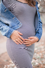 Happy pregnant woman hugging her tummy