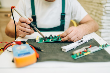 Repairman fixing problem with refrigerator at home