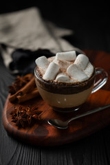coffee with milk and marshmallow with cinnamon and anise on wooden background	