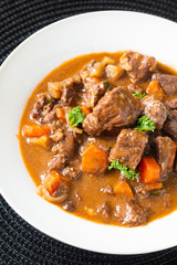 Food concept french classic beefs stew estouffade de boeuf in white ceramic plate with copy space