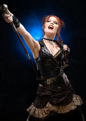 Beautiful redhead cosplayer girl wearing a Victorian-style steampunk costume with a big breast in a deep neckline screams and points up with cane in her hand on a black and blue background.