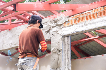 Construction workers plastering building wall